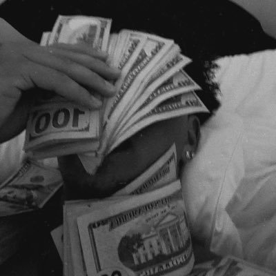 DG's black and white profile image holding cash